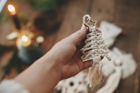 Arbolito de Navidad de macramé hecho a mano sobre mesa rústica